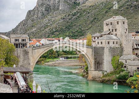 Un bellissimo ponte attraversa un fiume che scorre e sullo sfondo, un maestoso castello si erge orgogliosamente sul fianco della collina Foto Stock