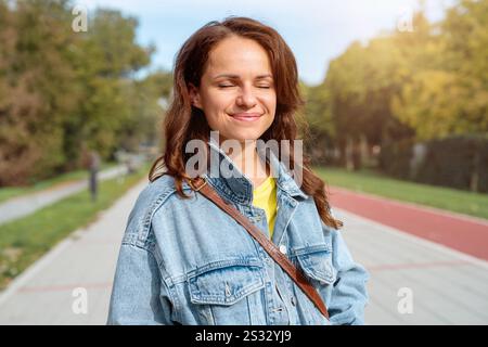 Giovane donna urbana spensierata che si gode una passeggiata all'aperto. Foto Stock