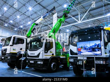 Kiev, Ucraina - 16 ottobre 2024: Due moderni camion commerciali IVECO sono parcheggiati in una sala coperta. Entrambi i carrelli sono bianchi e dotati di gru, per Foto Stock