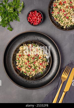 Fotografia gastronomica di tabouleh di insalata con melograno, bulgur; prezzemolo, menta, pomodoro, cipolla primaverile, piatto vegano, cibo arabo Foto Stock