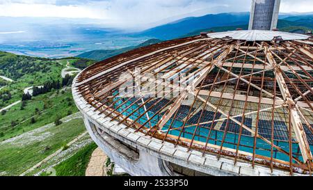 Questa immagine cattura una vista aerea che mostra un edificio unico che presenta una piscina situata elegantemente sul suo tetto Foto Stock
