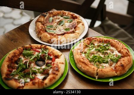 Delizioso assortimento di pizze con vari condimenti, perfetto per la condivisione e per gli incontri serali con pizza. Deliziose pizze assortite Foto Stock