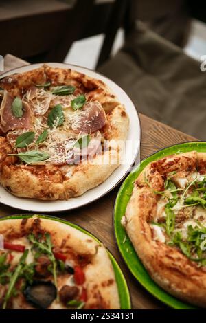 Delizioso assortimento di pizze con vari condimenti, perfetto per la condivisione e per gli incontri serali con pizza. Deliziose pizze assortite Foto Stock