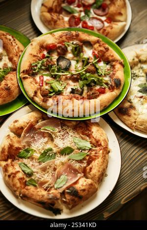 Delizioso assortimento di pizze con vari condimenti, perfetto per la condivisione e per gli incontri serali con pizza Foto Stock