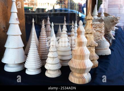 Fiera di Natale tra le montagne d'Italia, Asiago. Alberi di Natale in legno fatti a mano. Concetto ecologico di giocattoli per bambini e decorazioni per la casa Foto Stock