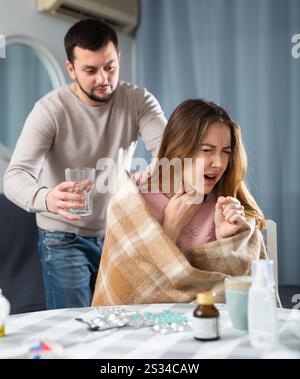 Donna malata che riposa a casa con il marito Foto Stock