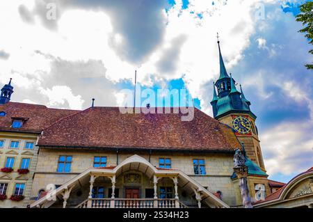 Municipio con Torre dell'Orologio e Statua in un giorno d'estate soleggiato nella città vecchia di Friburgo, Canton Friburgo, Svizzera. Foto Stock