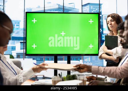 Dipendenti e investitori che partecipano a un briefing accanto alla visualizzazione isolata dello spazio di copia, esaminando gli indicatori economici e le metriche di performance. Team di lavoro che discute della pianificazione finanziaria. Foto Stock