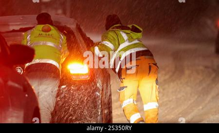 Intensive Schneefälle auf Grund einer Luftmassengrenze sorgten in der Eifel für einige Probleme. Bis zu 10 cm Neuschnee fielen bis Mitternacht. Die Straßen waren spiegelglatt. Der Winterdienst War im Einsatz, konnte aber nicht überall gleichzeitig sein. VOR allem an Steigungen blieben Fahrzeuge hängen. Auch die Autobahnen waren mit Schnee bedeckt. A Laubach Eifel War Muskelkraft gefragt. Un einer Steigung der L 52 fuhr sich ein PKW Fest. Es rückten kräftige Männer eines Sicherheitsdienstes an. Teilweise zu 5. Schoben sie den BMW den Berg hinauf. über 2 km da Unterbrechungen - ein Kraf Foto Stock