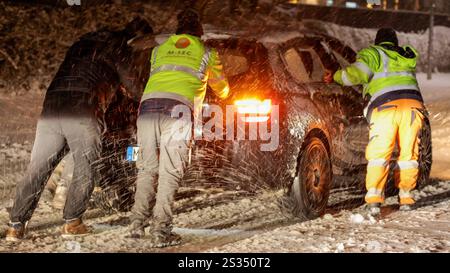 Intensive Schneefälle auf Grund einer Luftmassengrenze sorgten in der Eifel für einige Probleme. Bis zu 10 cm Neuschnee fielen bis Mitternacht. Die Straßen waren spiegelglatt. Der Winterdienst War im Einsatz, konnte aber nicht überall gleichzeitig sein. VOR allem an Steigungen blieben Fahrzeuge hängen. Auch die Autobahnen waren mit Schnee bedeckt. A Laubach Eifel War Muskelkraft gefragt. Un einer Steigung der L 52 fuhr sich ein PKW Fest. Es rückten kräftige Männer eines Sicherheitsdienstes an. Teilweise zu 5. Schoben sie den BMW den Berg hinauf. über 2 km da Unterbrechungen - ein Kraf Foto Stock