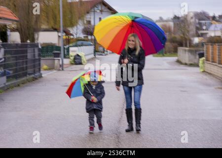 Madre e bambino con ombrello, simbolo di solidarietà, aiuto, pacchetto di aiuti, ombrello di salvataggio Austria Foto Stock