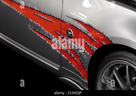 Primo piano di una fiamma rossa su un parafango di un'auto Foto Stock