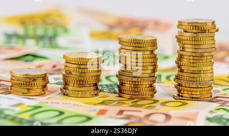 Pila di monete, curva in aumento, foto simboliche per l'aumento dei profitti e anche per l'aumento dei costi Foto Stock