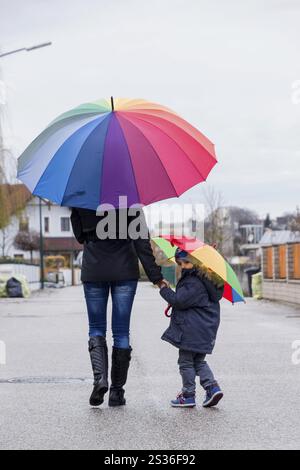Madre e bambino con ombrello, simbolo di solidarietà, aiuto, pacchetto di aiuti, ombrello di salvataggio Austria Foto Stock