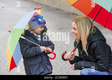 Madre e bambino con ombrello, simbolo di solidarietà, aiuto, pacchetto di aiuti, ombrello di salvataggio Austria Foto Stock