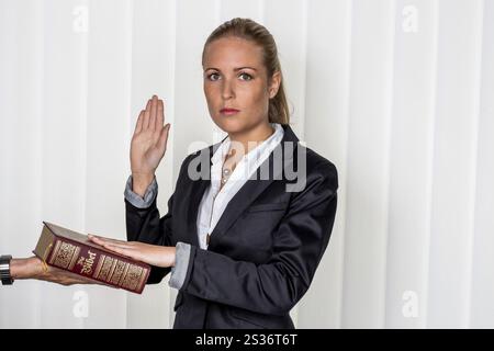 Una donna testimonia come testimone in un caso giudiziario. Ha giurato e giura sulla Bibbia. Austria Foto Stock