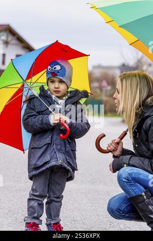 Madre e bambino con ombrello, simbolo di solidarietà, aiuto, pacchetto di aiuti, ombrello di salvataggio Austria Foto Stock