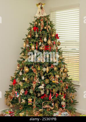 Un albero decorato di Natale e regali ordinatamente disposti intorno alla base pronti per un incontro di famiglia su albero di Natale Foto Stock