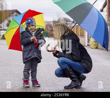 Madre e bambino con ombrello, simbolo di solidarietà, aiuto, pacchetto di aiuti, ombrello di salvataggio Austria Foto Stock