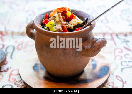 Viaggia in Georgia: Mangia il Chanakhi (piatto tradizionale georgiano di stufato di agnello con pomodori, melanzane, patate, verdure e aglio) in vaso da vicino Foto Stock