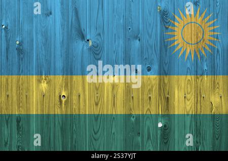 Bandiera del Ruanda raffigurata in colori vivaci su una vecchia parete di legno da vicino. Striscione testurizzato su sfondo ruvido. Bandiera del Ruanda raffigurata con vernice brillante Foto Stock