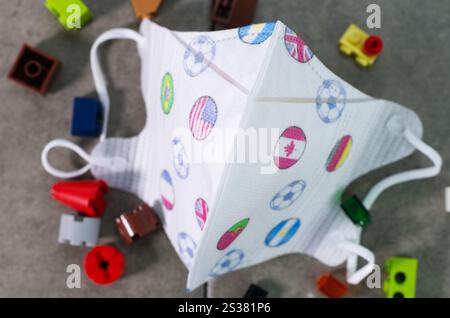 Maschera colorata con bandiere e blocchi su una superficie grigia Foto Stock