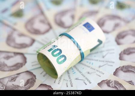 Un sacco di centinaia di banconote in euro si trova su molte banconote di hryvna ucraine. Default economico, crisi e svalutazione della valuta nazionale ucraina du Foto Stock