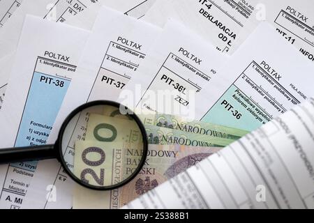 Soldi zloty polacchi e lente d'ingrandimento su una grande quantità di moduli fiscali polacchi da vicino. La contabilità, la burocrazia e la routine dei contribuenti in Polonia. Polacco Foto Stock