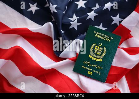 Passaporto verde della Repubblica Islamica del Pakistan sullo sfondo della bandiera nazionale degli Stati Uniti da vicino. Concetto di turismo e diplomazia Foto Stock