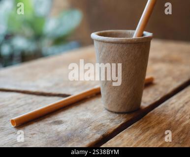 Una tazza in ceramica con due bastoncini di legno che sporgono da essa, creando un aspetto unico e non convenzionale. I bastoncini sono saldamente piantati nella tazza, ad Foto Stock