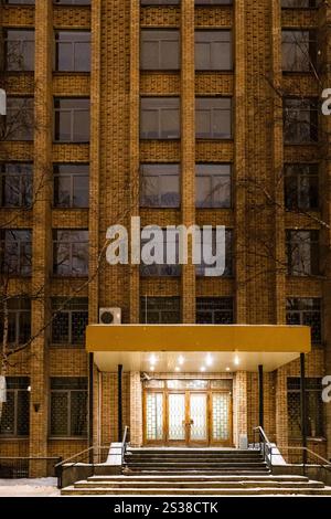 Portico e ingresso all'edificio a più piani della città di Mosca in serata d'inverno Foto Stock
