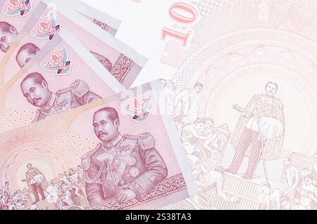 100 banconote in Baht thailandesi sono impilate sullo sfondo di grandi banconote semitrasparenti. Sfondo aziendale astratto con spazio di copia. 100 banconote in Baht tailandesi Foto Stock