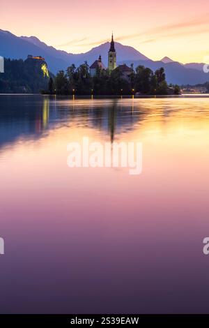 Vista sul lago di Bled in primavera con la piccola isola e l'Assunzione di Maria all'alba. Bled, alta Carniola, Slovenia. Foto Stock