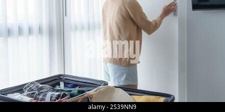 Ragazza asiatica che prepara le vacanze scegliendo i vestiti con guardaroba in camera da letto prima del viaggio delle vacanze. Foto Stock