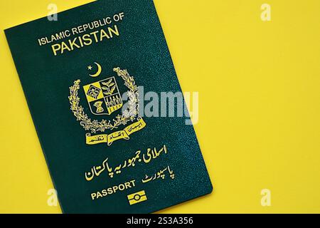 Passaporto verde della Repubblica Islamica del Pakistan su sfondo giallo da vicino. Concetto di turismo e cittadinanza Foto Stock