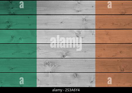 Bandiera dell'Irlanda raffigurata in colori vivaci su una vecchia parete di legno da vicino. Striscione testurizzato su sfondo ruvido. Bandiera dell'Irlanda raffigurata con vernice brillante Foto Stock