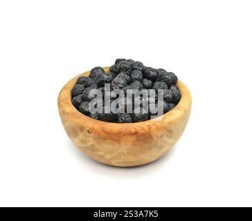 Frutti di Aronia in una ciotola di legno isolata su sfondo bianco. Bacche di cioccolato nero o aronia, isolate su sfondo bianco. Foto Stock
