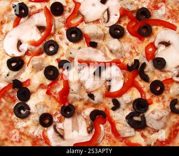 Pizza al peperoni con funghi, gamberi e olive sullo sfondo. Pizza al peperoni con funghi, gamberi e olive Foto Stock