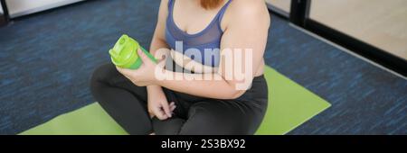 Obesa donna asiatica dieta perdita di peso in abbigliamento sportivo bere bevanda sana. Grasso asiatico sportivo femminile che beve proteina scuotere dopo l'esercizio fisico per bene energia Foto Stock