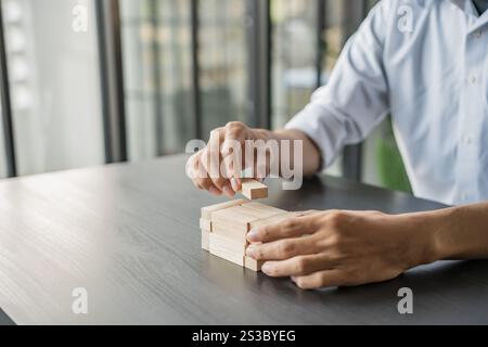 Pianificazione del rischio e strategia nel gioco d'azzardo degli imprenditori collocando blocchi di legno.concetto di business per il processo di successo della crescita Foto Stock