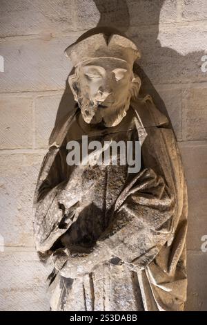 Dettaglio di una statua in pietra medievale intagliata di un vescovo all'interno della storica cattedrale di Notre Dame a Bayeux, Normandia, Francia Foto Stock