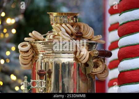Samovar tradizionale russo con bagel sulla strada invernale sullo sfondo delle decorazioni di Capodanno Foto Stock