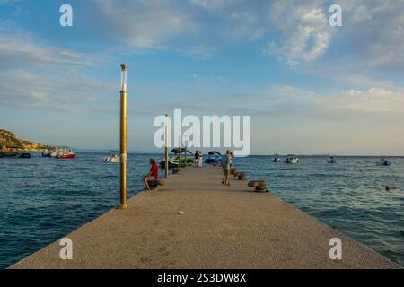 Himare, Albanese - 8 giugno 2024. Crepuscolo presso un molo sulla Spile Beach nella baia di Himare sulla costa dell'Albania meridionale, parte della riviera albanese. Foto Stock