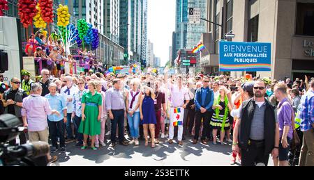 Leader e membri della comunità che marciano in solidarietà alla parata del Montreal Pride, celebrando la diversità e i diritti LGBTQ+ Foto Stock