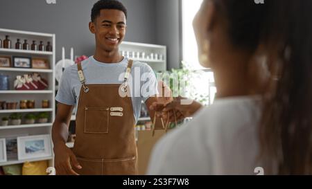 Uomo che consegna una borsa della spesa a una donna in un negozio di arredamento ben arredato, suggerendo una piacevole esperienza di shopping in un negozio di arredamento per la casa Foto Stock