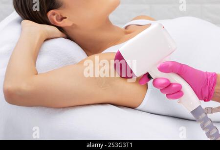 Procedura di epilazione Elos sul corpo di una donna. Estetista che fa ringiovanimento laser in un salone di bellezza. Rimozione dei peli superflui. Hardware Foto Stock