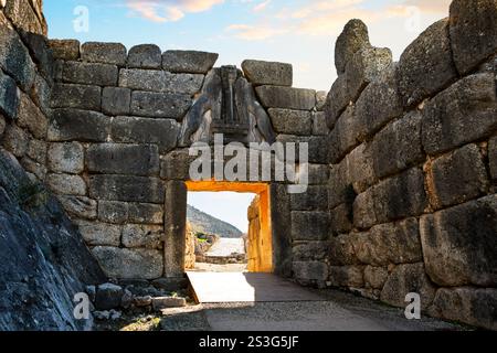 Il sole tramonta dietro l'ingresso dell'antica porta dei leoni al sito archeologico di Micene, una cittadella greca dell'età del bronzo nella regione del Peloponneso. Foto Stock