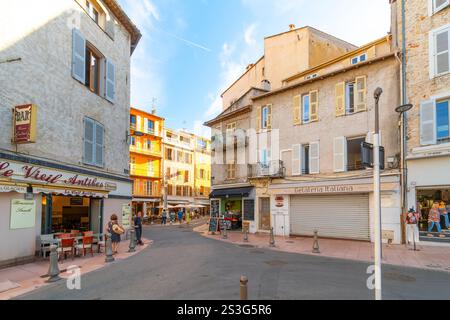 Negozi colorati e caffetterie lungo la storica Rue de la Republique nella pittoresca città vecchia di Antibes, Francia, Costa Azzurra. Foto Stock