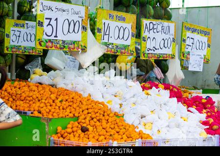 Il mercato della frutta di alimentari vende vari tipi di frutta. Longan fresco, arancia, pera e mela mostrati sul rack pronto per la vendita Foto Stock