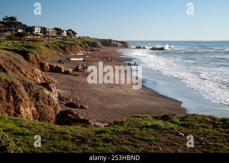 Moonstone Beach in California in un giorno di dicembre soleggiato con le onde che si infrangono dolcemente sulla spiaggia sabbiosa accanto all'Oceano Pacifico. Foto Stock